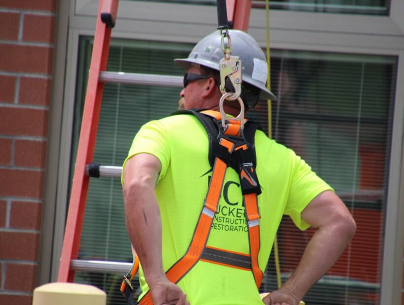 man on a ladder using protective equipment