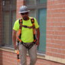 construction worker on site wearing safety harness and helmet