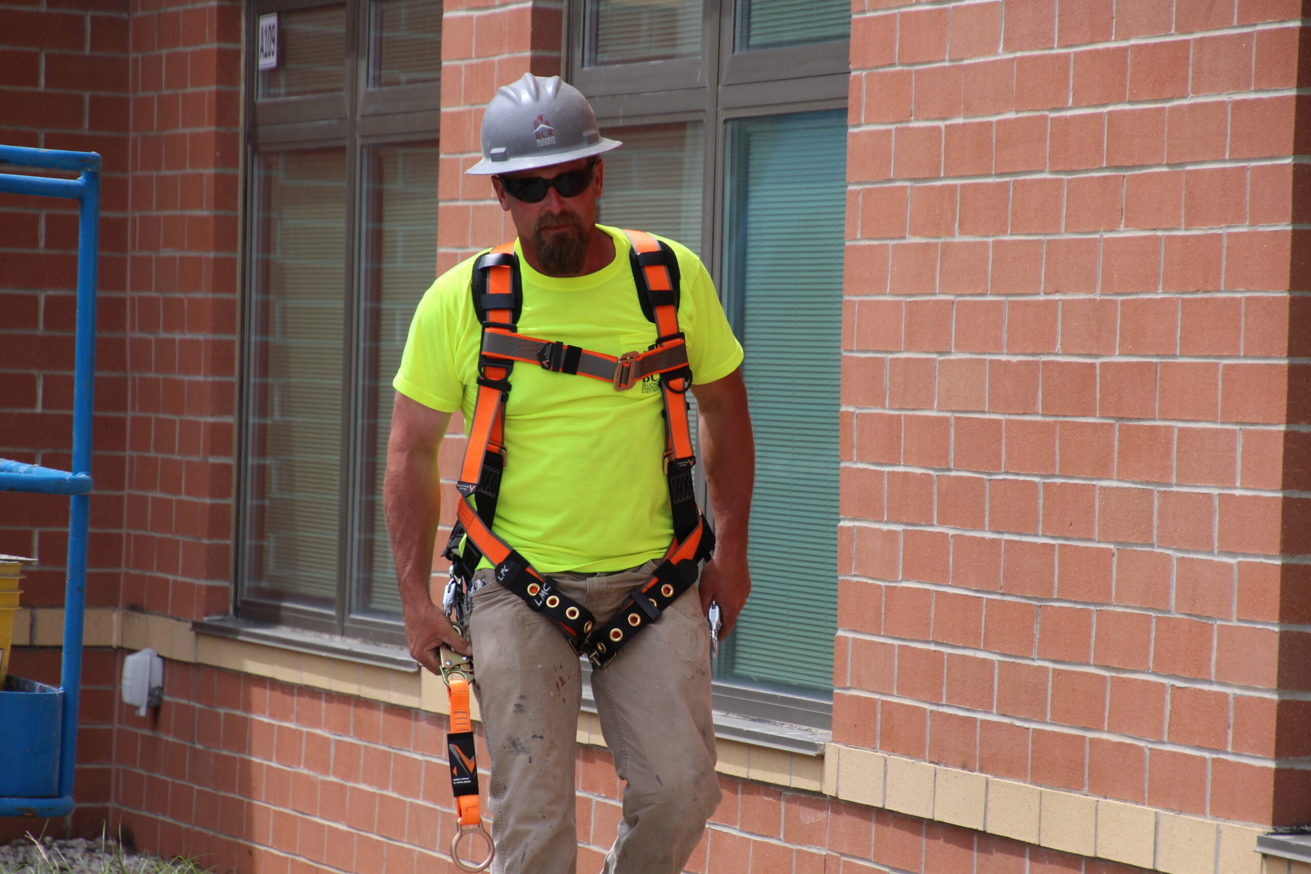 construction worker on site wearing safety harness and helmet