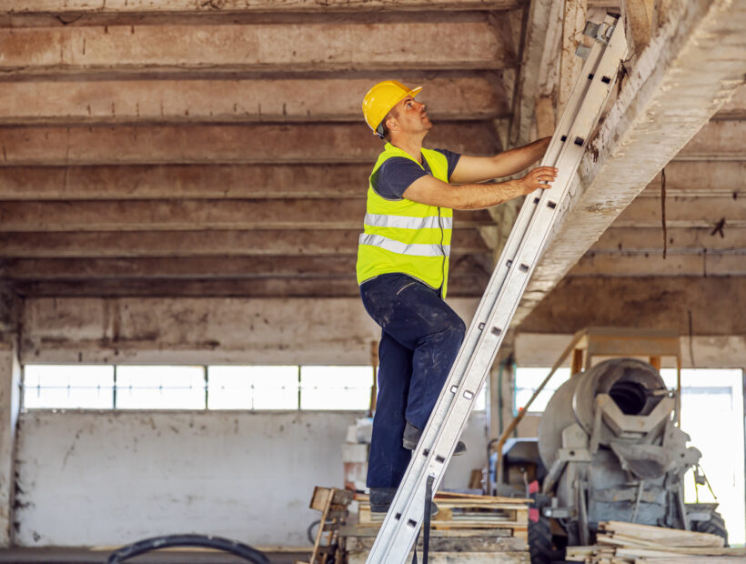 Construction site builder climbing on ladder