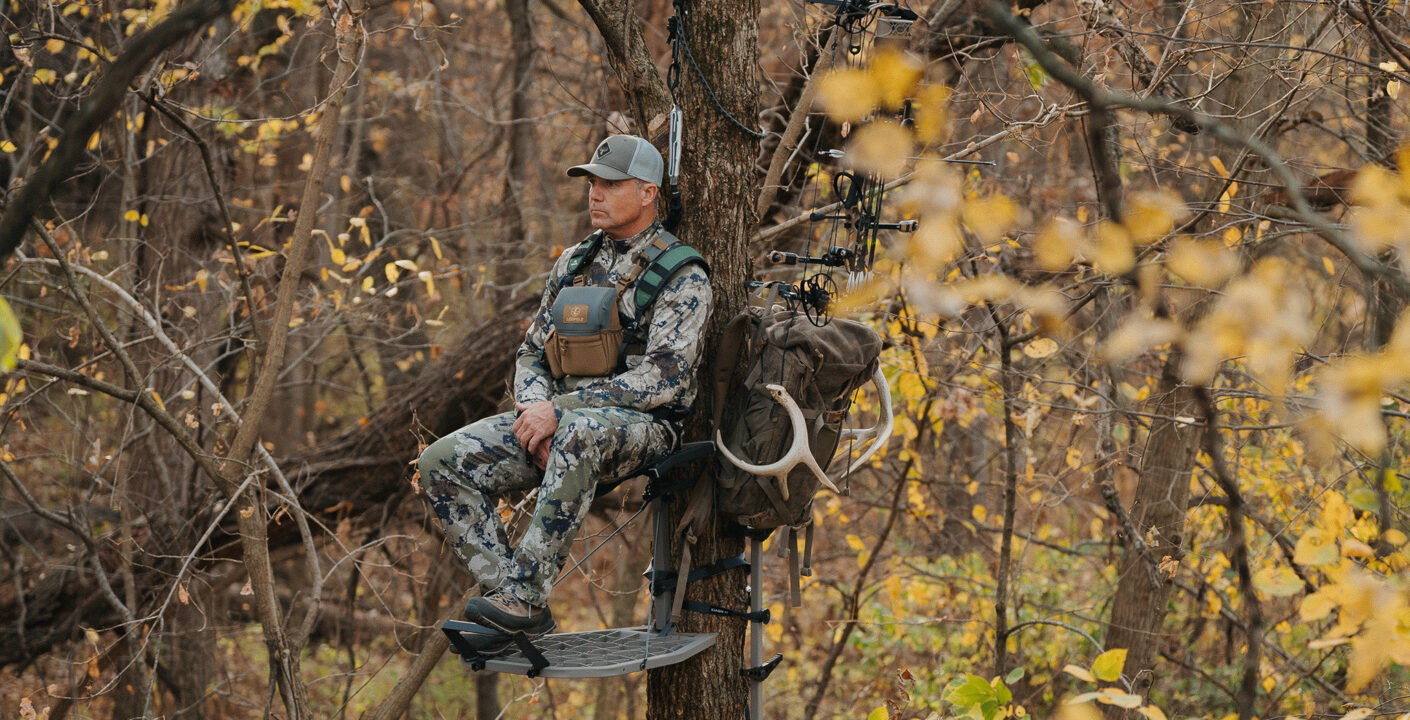 A man sitting in a tree stand wearing Malta hunting gear